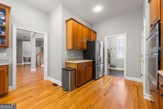 kitchen featuring stainless steel fridge and light hardwood / wood-style floors