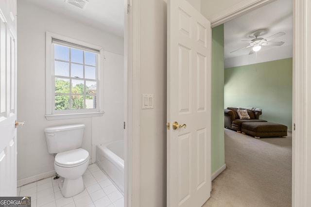 bathroom with tile patterned floors, toilet, ceiling fan, and a tub