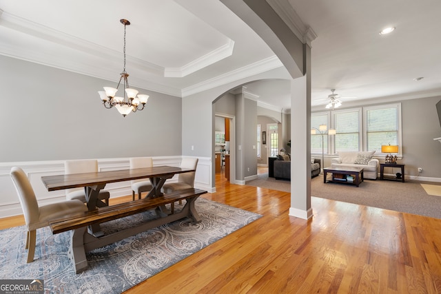 dining area featuring light hardwood / wood-style flooring, ceiling fan with notable chandelier, and ornamental molding