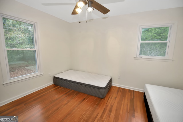 bedroom with multiple windows, ceiling fan, and hardwood / wood-style floors