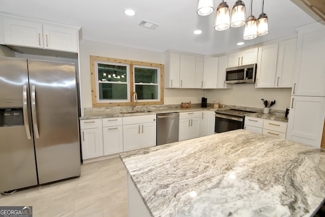 kitchen featuring white cabinets, appliances with stainless steel finishes, hanging light fixtures, and sink