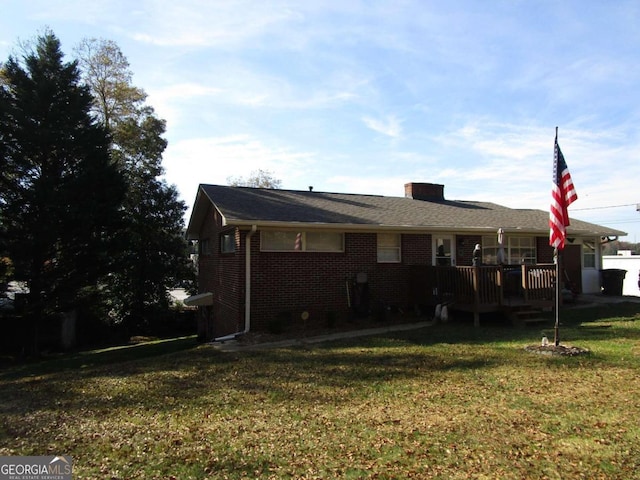 rear view of house featuring a yard and a deck