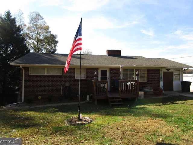 rear view of property with a deck and a yard