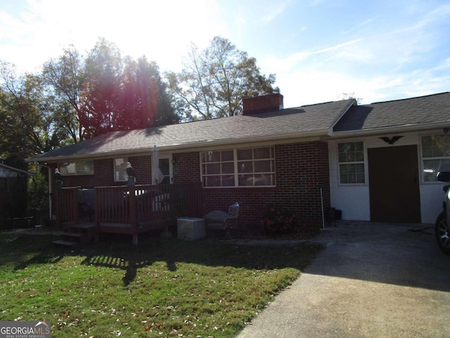 back of property featuring a lawn and a wooden deck