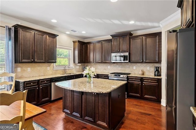 kitchen with dark hardwood / wood-style floors, a center island, sink, and appliances with stainless steel finishes