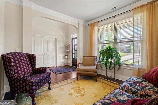 living area with hardwood / wood-style floors and crown molding