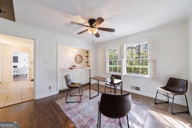 office area with ceiling fan, ornamental molding, and dark wood-type flooring