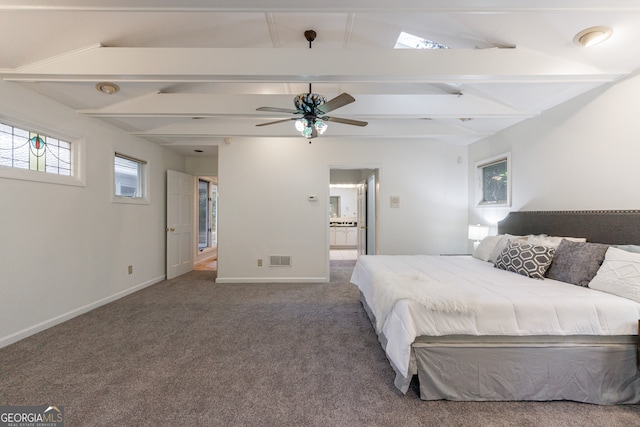 bedroom featuring connected bathroom, lofted ceiling with beams, ceiling fan, and dark carpet