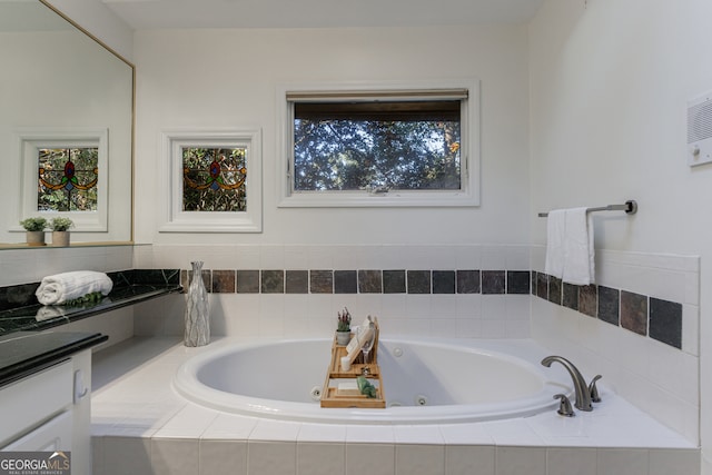 bathroom featuring vanity and tiled bath