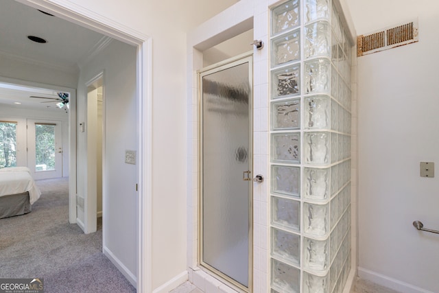 bathroom with a shower, ceiling fan, and ornamental molding