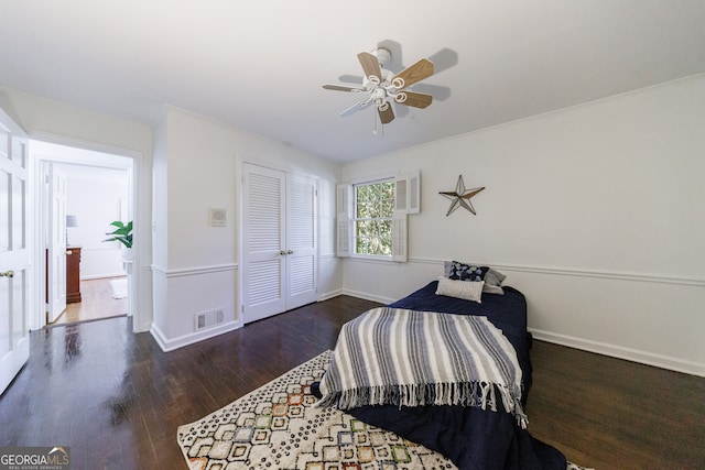 bedroom with a closet, ceiling fan, and dark wood-type flooring