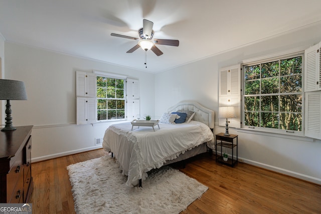 bedroom with ceiling fan, crown molding, and dark hardwood / wood-style floors