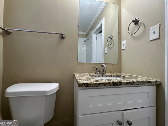 bathroom featuring toilet, vanity, and ornamental molding