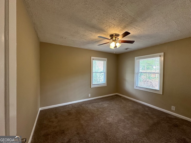 carpeted spare room featuring ceiling fan and a textured ceiling