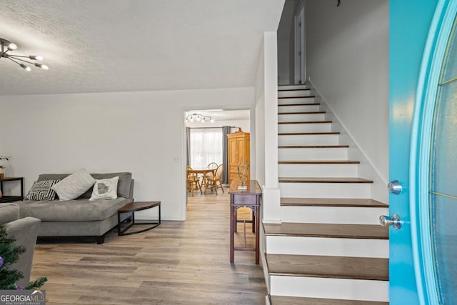 interior space featuring hardwood / wood-style floors, a notable chandelier, and a textured ceiling