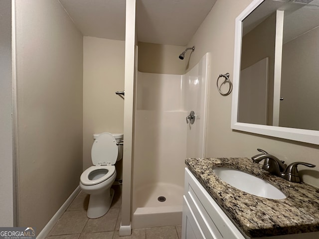 bathroom with tile patterned flooring, vanity, toilet, and walk in shower