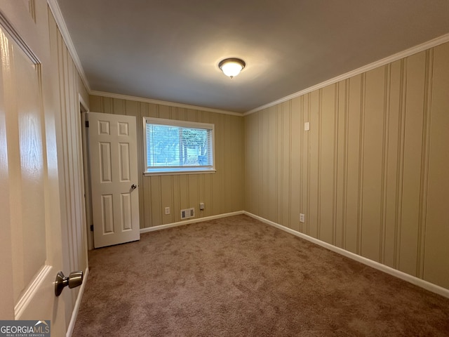 empty room featuring carpet flooring and ornamental molding