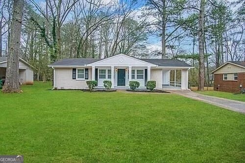 single story home featuring covered porch, a front yard, and a carport