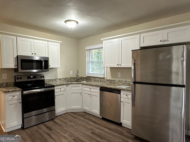 kitchen featuring appliances with stainless steel finishes, white cabinetry, and sink