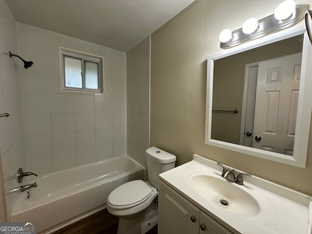 full bathroom featuring hardwood / wood-style floors, vanity, toilet, and tiled shower / bath