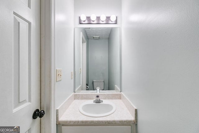 bathroom featuring vanity and toilet