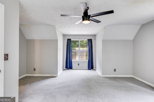 bonus room featuring a textured ceiling, ceiling fan, light colored carpet, and vaulted ceiling