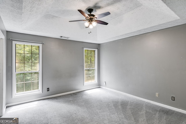 spare room with carpet flooring, ceiling fan, and a textured ceiling