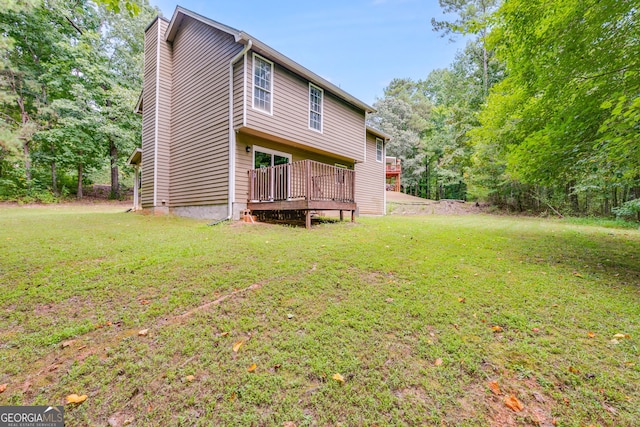 back of house with a deck and a yard