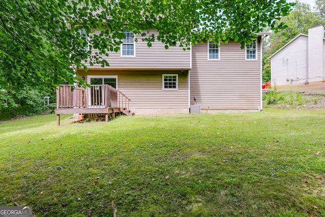 rear view of property with a lawn and a wooden deck