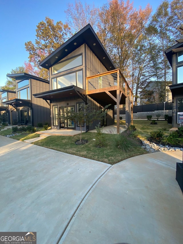 back of property with a deck and a lawn