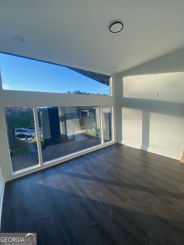 empty room featuring lofted ceiling and dark hardwood / wood-style floors