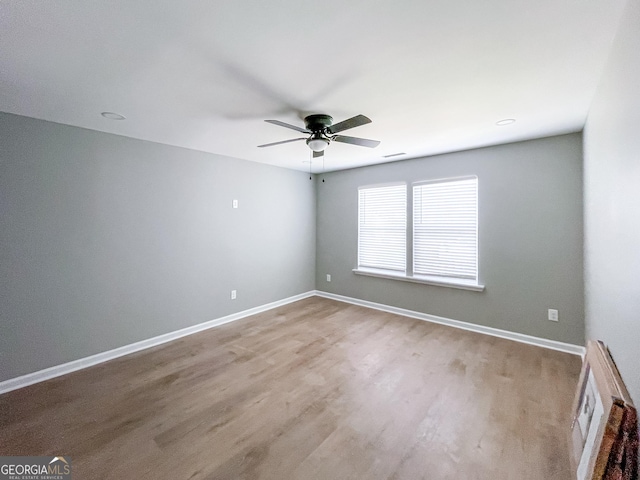 empty room featuring visible vents, ceiling fan, baseboards, and wood finished floors