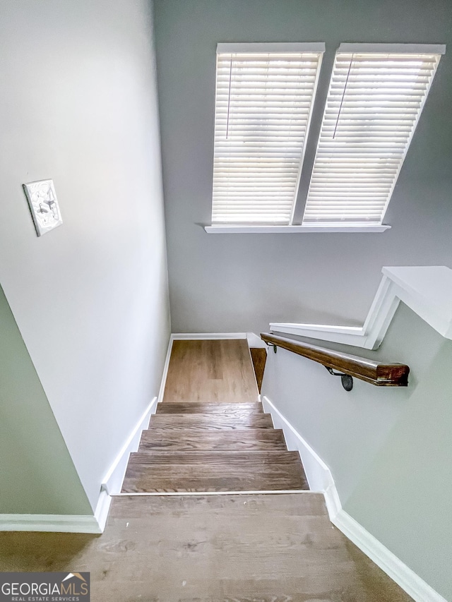 stairway with baseboards and wood finished floors