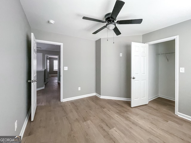 unfurnished bedroom featuring light wood finished floors, a ceiling fan, and baseboards