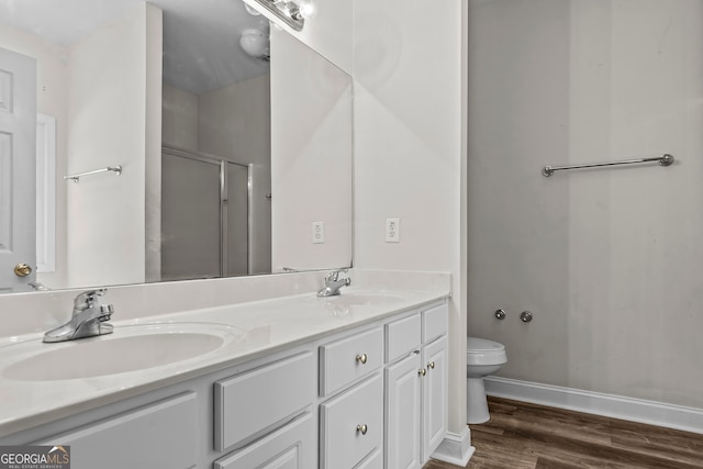 bathroom featuring hardwood / wood-style flooring, vanity, toilet, and a shower with door