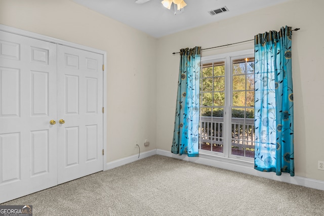 carpeted empty room featuring ceiling fan