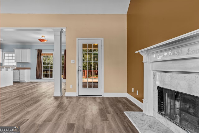 unfurnished living room featuring a premium fireplace, hardwood / wood-style floors, and crown molding