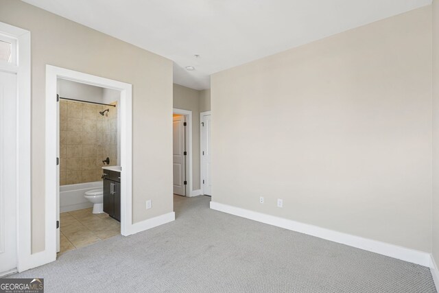 unfurnished bedroom with light carpet and ensuite bathroom