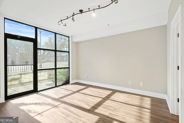 empty room featuring hardwood / wood-style flooring and floor to ceiling windows