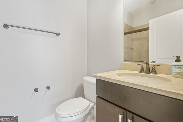 bathroom featuring tiled shower, vanity, and toilet