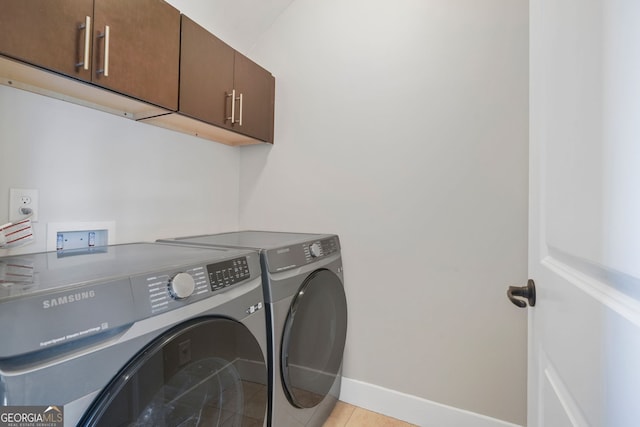 washroom with washer and dryer, light tile patterned flooring, and cabinets