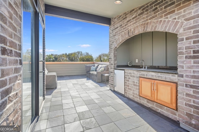 view of patio featuring an outdoor kitchen and sink