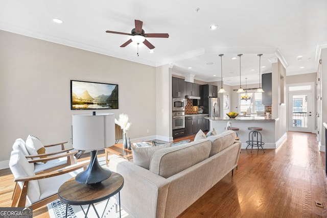 living room with dark hardwood / wood-style flooring, ceiling fan, and crown molding