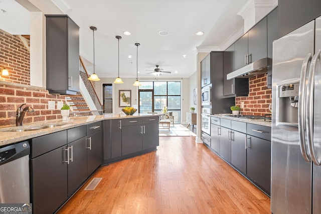 kitchen featuring sink, light hardwood / wood-style flooring, ceiling fan, decorative light fixtures, and stainless steel appliances