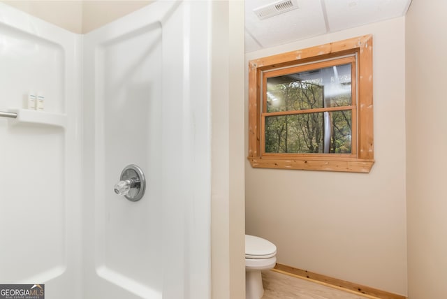 bathroom with toilet, wood-type flooring, and walk in shower