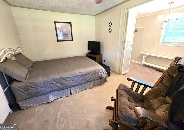 bedroom with carpet, ornamental molding, a textured ceiling, and a notable chandelier