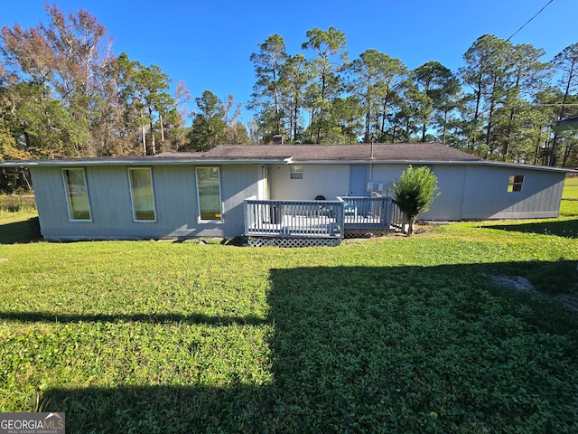 back of house featuring a wooden deck and a lawn