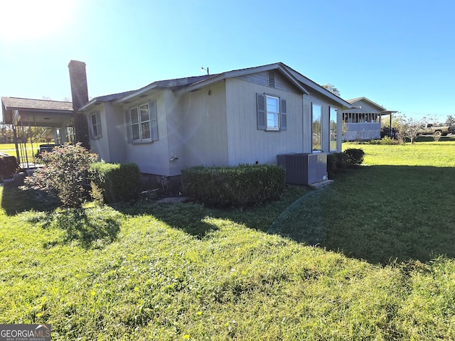 view of home's exterior with a yard and central AC unit