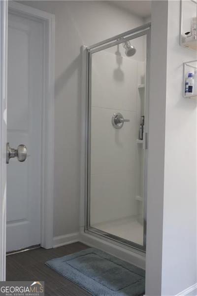 bathroom featuring wood-type flooring and walk in shower