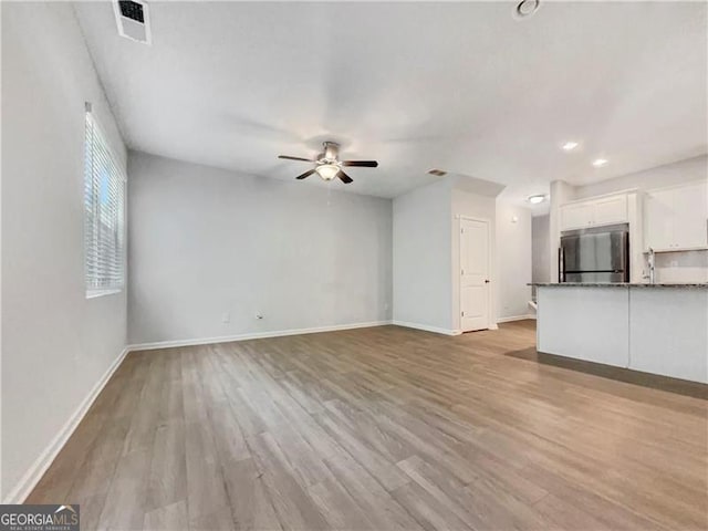 unfurnished living room with light hardwood / wood-style flooring and ceiling fan